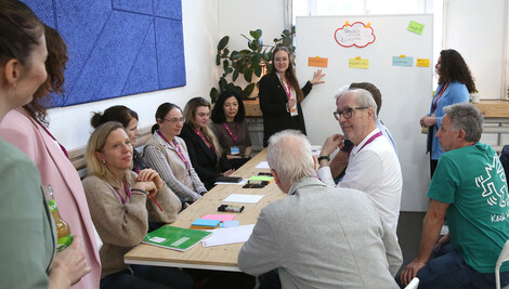 Personen um eine Tisch gruppiert, Workshop #Fokusversorgung