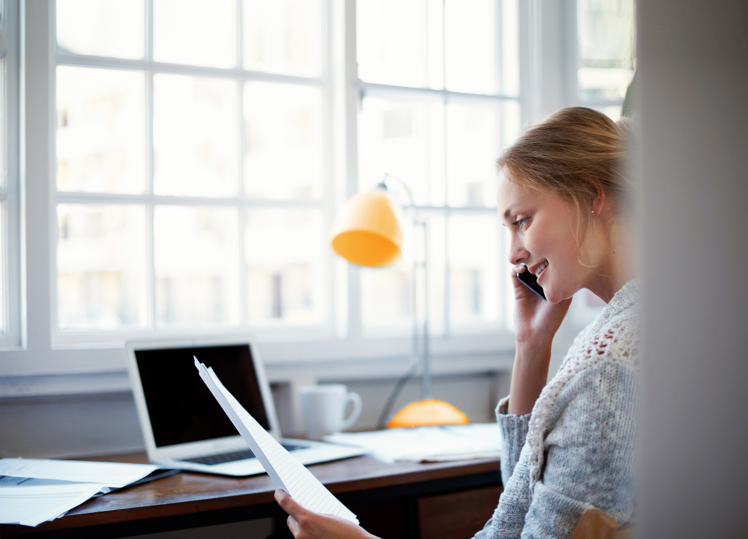 Telefonierende Frau am Schreibtisch