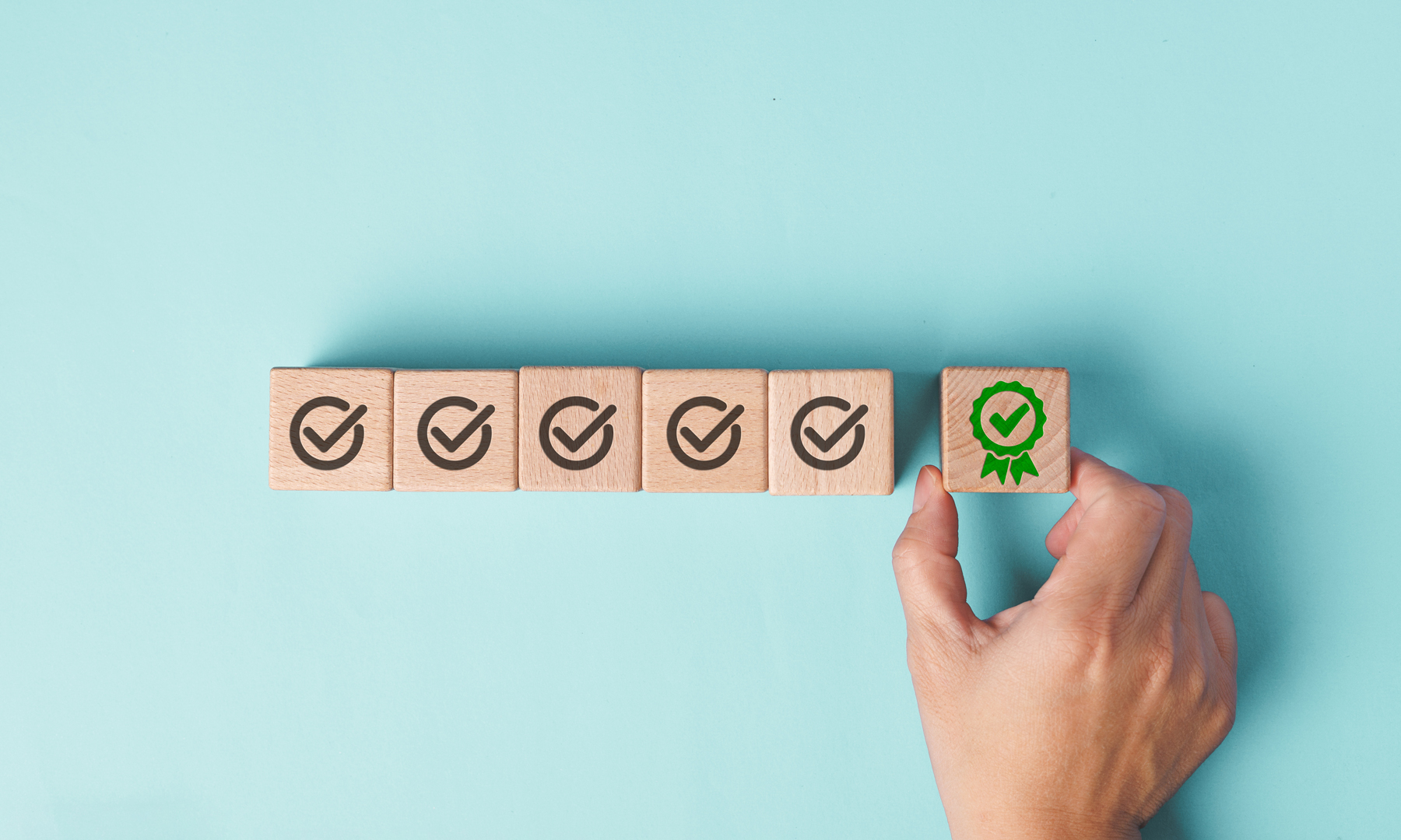 Hand platziert Holzblock mit grünen Zertifikatshaken