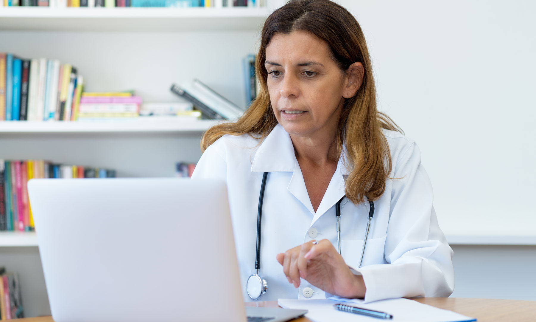Älterer Ärztin schaut in die digitale Patientenakte.
